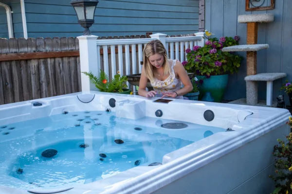 woman using tablet beside clearwater spa on patio with fountain