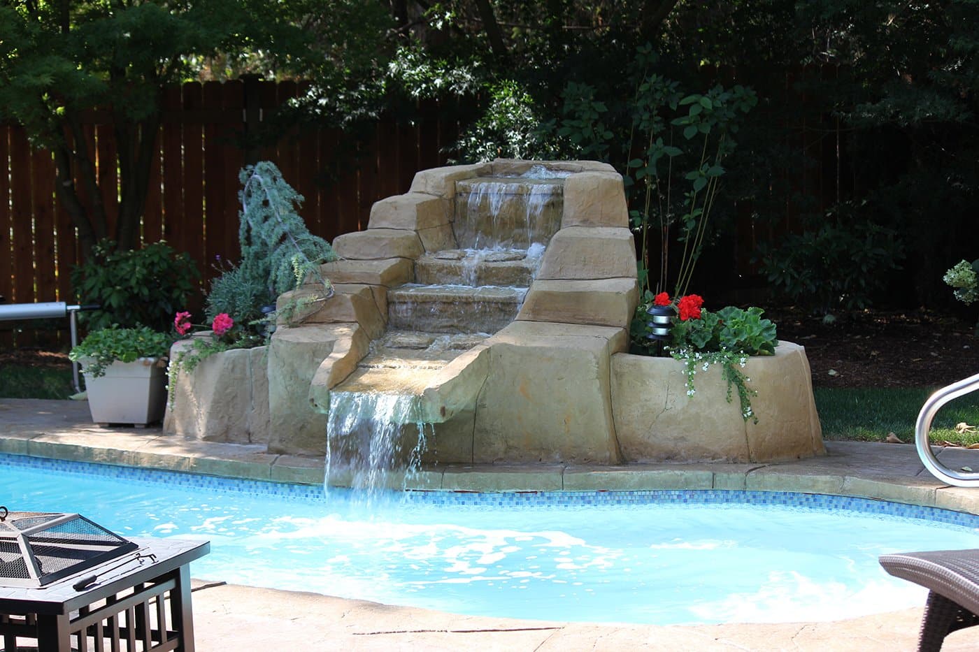 in-ground pool with natural rock waterfall
